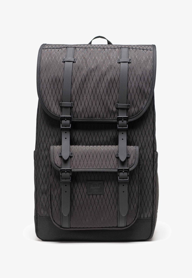 Sac à dos noir à motif losange, accents en cuir, et fermeture à double sangle. Comprend une poche avant et un design en tissu texturé.