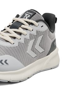 Grijze sneakers van gaas met crèmekleurige veters, een gestructureerd ontwerp en een opvallend logo. Voorzien van een fijn dempend zool en een versterkte hiel voor extra ondersteuning.