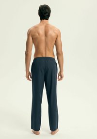 Męskie granatowe spodnie kąpielowe z elastycznym pasem, lekkiego materiału, luźny krój, bez widocznych wzorów ani akcentów.