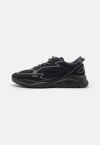Scarpe sportive nere con tomaia in mesh e suede, accenti grigi testurizzati, punte arrotondate e suola in gomma. Logo "HUGO" sul lato.