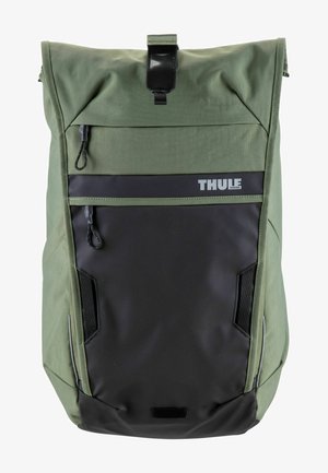 Sac à dos Thule en tissu olive durable avec des accents noirs, fermeture roulée, poche zippée à l'avant et panneaux latéraux en mesh.