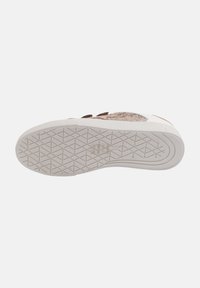 Baskets avec un dessus texturé marron et beige, dotées d'une semelle en caoutchouc blanche épaisse avec un motif de crampons en losange. Les accents incluent un branding discret.