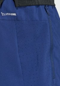 Μπλε σκούρο σορτς με λογότυπο CLIMACOOL, με διάτρητη υφή στη μία πλευρά και τσέπη με φερμουάρ. Κατασκευασμένα από ελαφρύ υλικό.