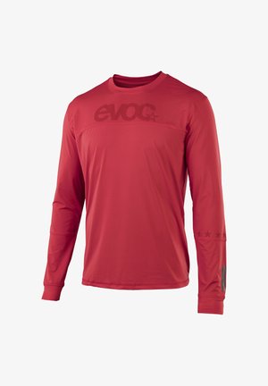 Red long-sleeve athletic shirt with crew neck, "evoc" logo across chest and left sleeve, and small star designs on right forearm.