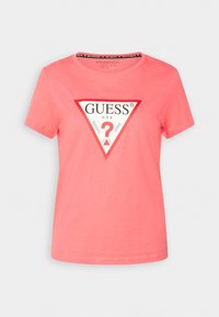 Koralowa bawełniana koszulka z krótkim rękawem, z okrągłym dekoltem, z trójkątnym logo w białym i czerwonym kolorze oraz napisem "GUESS U.S.A. WASHED JEANS."