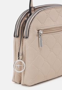 Borsa a mano beige con texture e motivo a diamante, con doppi scomparti con zip e hardware argentato. Presenta un'etichetta circolare logata staccabile.