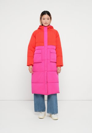 Manteau matelassé avec la partie supérieure rouge vif et la partie inférieure rose, une capuche, des poches avant et une silhouette droite.