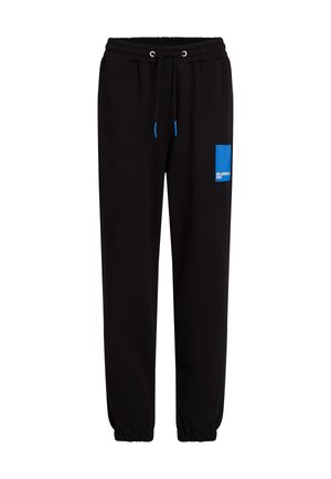 Pantalons de jogging noirs avec taille élastique, cordon de serrage et poignets. Présente un patch logo rectangulaire bleu sur la cuisse gauche. Texture lisse.
