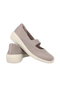 Zapatos slip-on de punto beige con puntera redonda, parte superior texturizada y correa elástica. Suela de goma con estrías sutiles y marca roja en la plantilla.