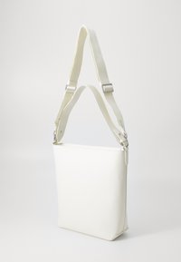 Borsa a spalla bianca in pelle con un design piatto, una forma strutturata e una tracolla testurizzata e regolabile. Presenta accessori in argento e una chiusura a zip.