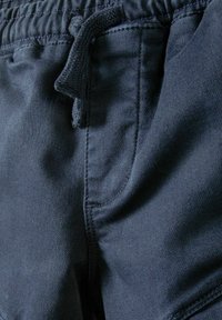 Marinblå shorts i ett texturerat tyg, med elastisk midja och dragsko. Har sidofickor och sydda detaljer.