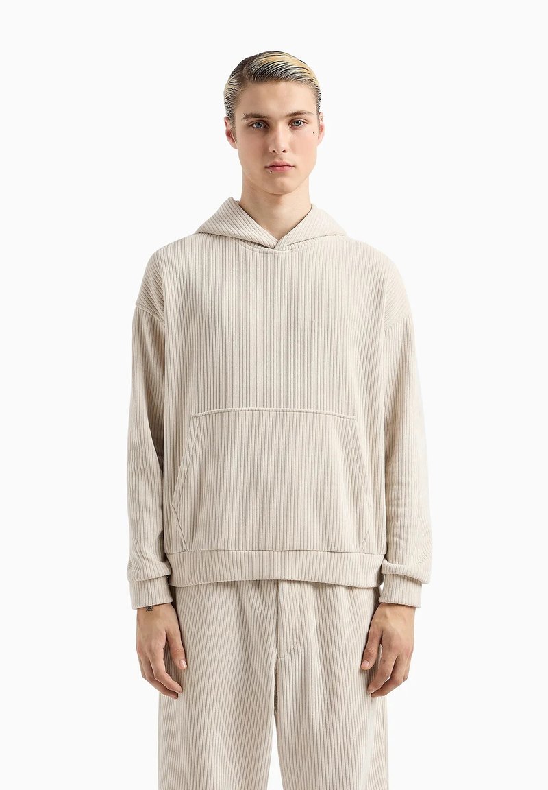 Felpa beige a coste con tasca frontale, vestibilità rilassata e cappuccio regolabile con coulisse. Presenta una consistenza morbida e maniche ampie.
