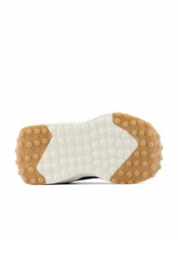 Semelle de chaussure avec une section centrale blanche et des grips en caoutchouc beige aux orteils et au talon, présentant des motifs circulaires sur un fond blanc.