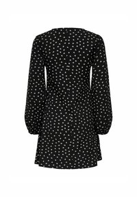 Robe noire à manches longues avec un petit motif floral blanc, présentant des manches légèrement bouffantes et un ourlet évasé, vue de l'arrière.