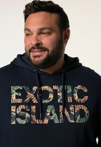 Felpa blu navy con grande scritta "ISOLA ESOTICA" e motivo con foglie tropicali. Include cappuccio regolabile e una consistenza morbida.