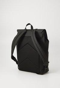 Mochila negra con un respaldo de malla texturizada, diseño de enrollado, correas acolchadas y un patrón geométrico. Fabricada con material duradero.