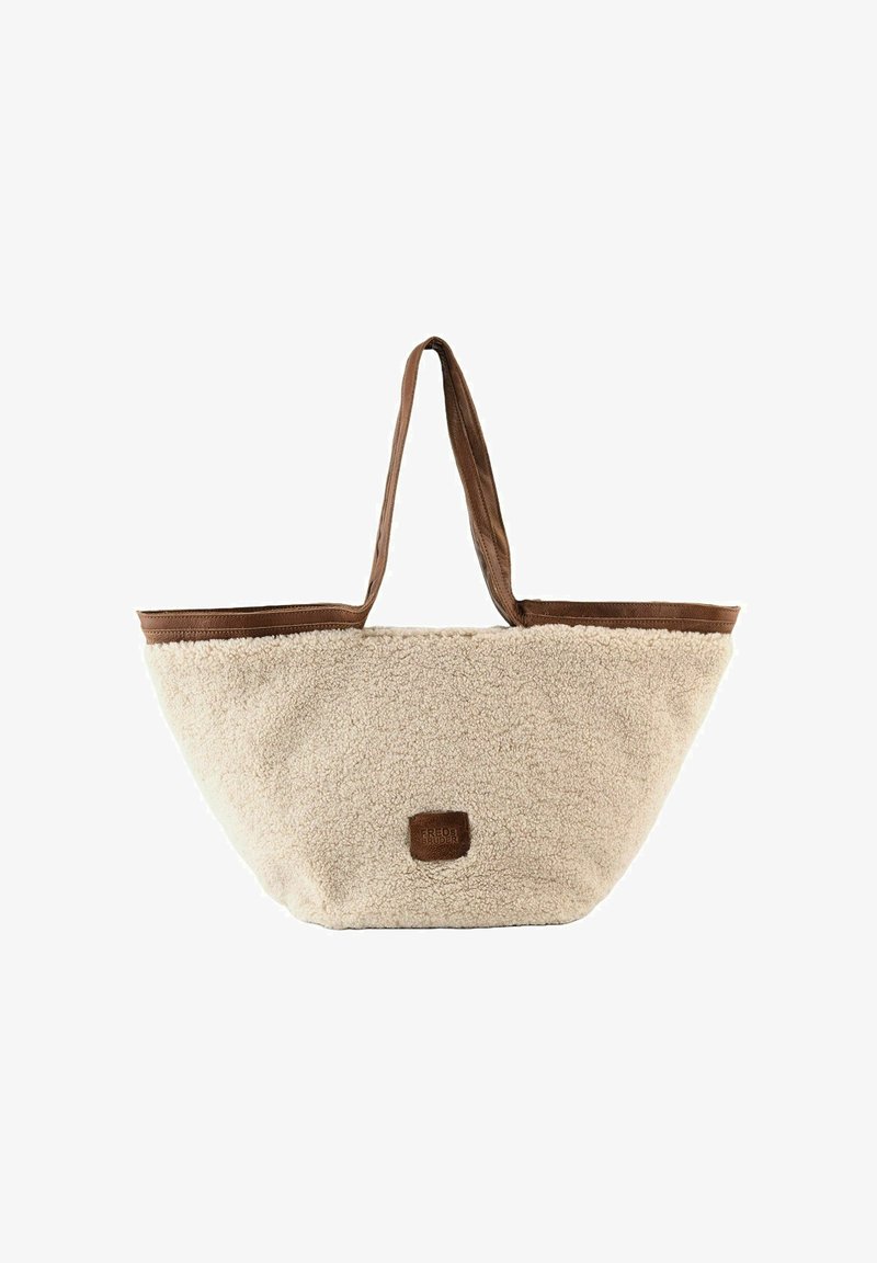 Beige faux-shearling tote bag met bruin leren accenten, dubbele handvatten en een vierkante logo patch. Ronde, brede vorm voor ruime opslag.