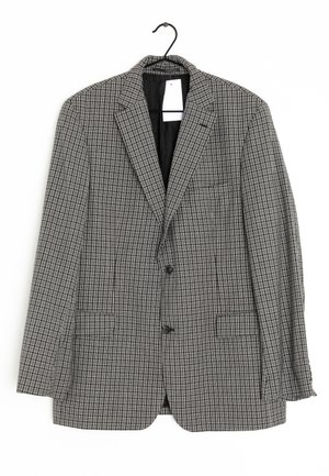 Blazer a cuadros gris y negro, de un solo botón con dos botones, solapas con muesca y dos bolsillos delanteros. Cuelga de un gancho negro.