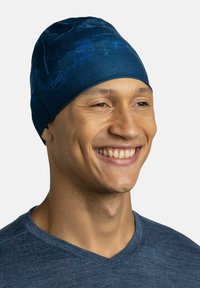 Navy blue stretchy beanie with a textured design, made from lightweight material. Buff logo visible on the front. Fits snugly on the head.