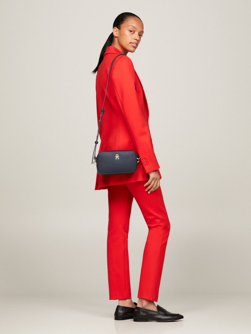 Červený propracovaný blejzr a kalhoty, černá crossbody taška a černé mokasíny. Hladká tkanina, strukturovaný design a minimalistické kovové detaily.