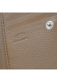 Binnenkant van een tan leren portemonnee met een gestructureerd oppervlak, zichtbare stiksels en een zilveren drukknoop met een reliëf RFID-logo.