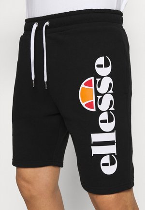 Czarne sportowe szorty z białymi sznurkami oraz dużym białym logo Ellesse z czerwonym i pomarańczowym półkolem na lewym udzie.