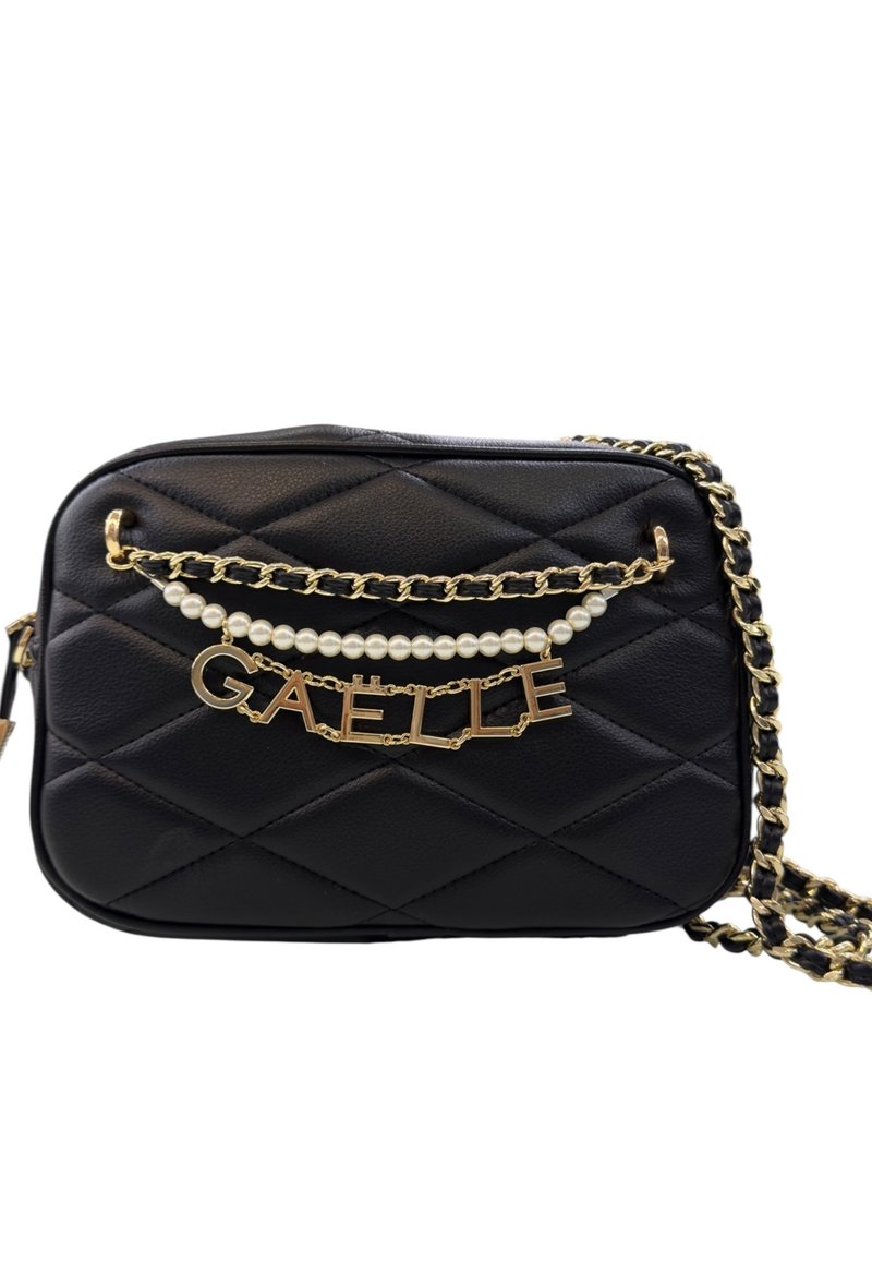 Borsa a tracolla nera in pelle trapuntata con tracolla in catena dorata, dettaglio in perla e lettere dorate che formano la scritta "GAËLLE" sul davanti.