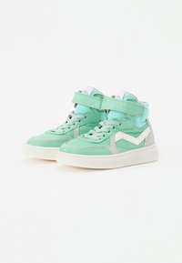 Zapatillas altas color verde menta hechas de materiales mixtos, con una correa de velcro, acentos grises contrastantes y suelas blancas.