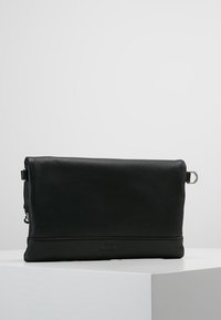 Czarna skórzana kopertówka o teksturowanej powierzchni, prostokątnym kształcie, zamknięciu na zamek oraz srebrnym akcentem metalowym. Subtelne oznaczenie marki na dole.