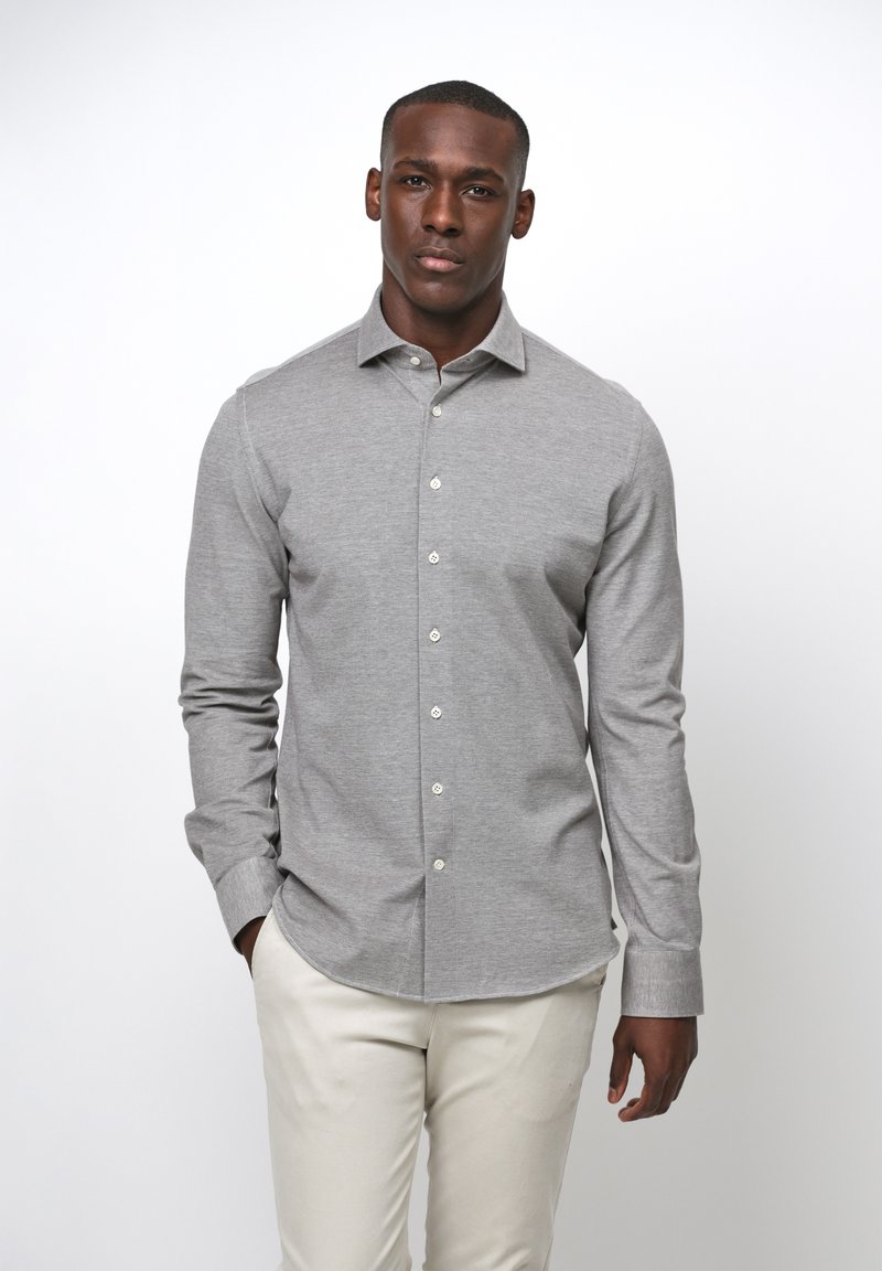 Camicia grigia a maniche lunghe con colletto classico. Realizzata in tessuto leggero, presenta una texture liscia e bottoni bianchi.