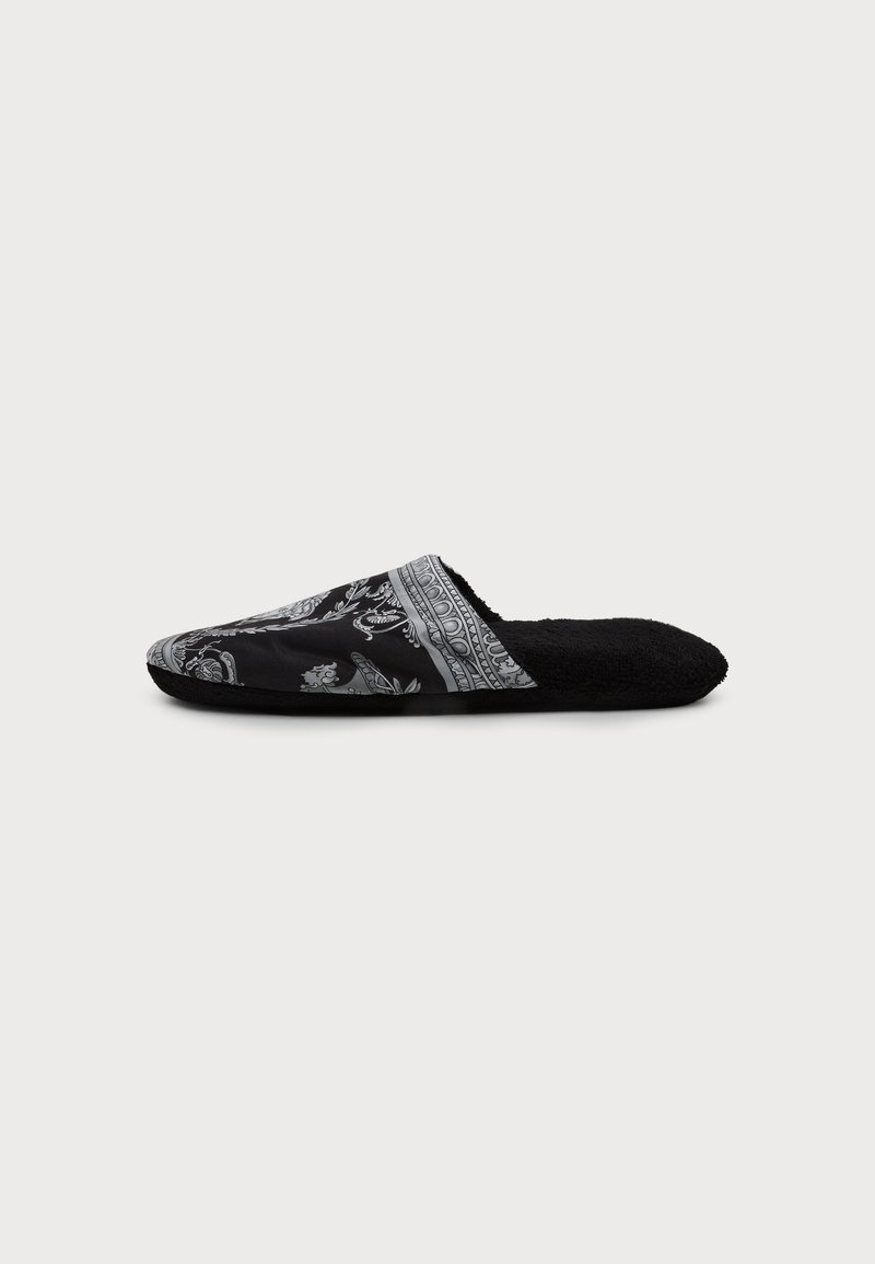 Black slip-on slipper with patterned fabric upper and soft fuzzy lining, shown in side profile on plain light background.