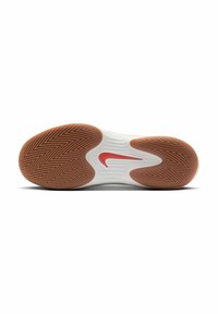 Nike Sportschuhsohle mit einer weißen Mittelsohle mit Rillen, einer strukturierten braunen Gummisohle und einem roten Nike-Swoosh-Akzent.