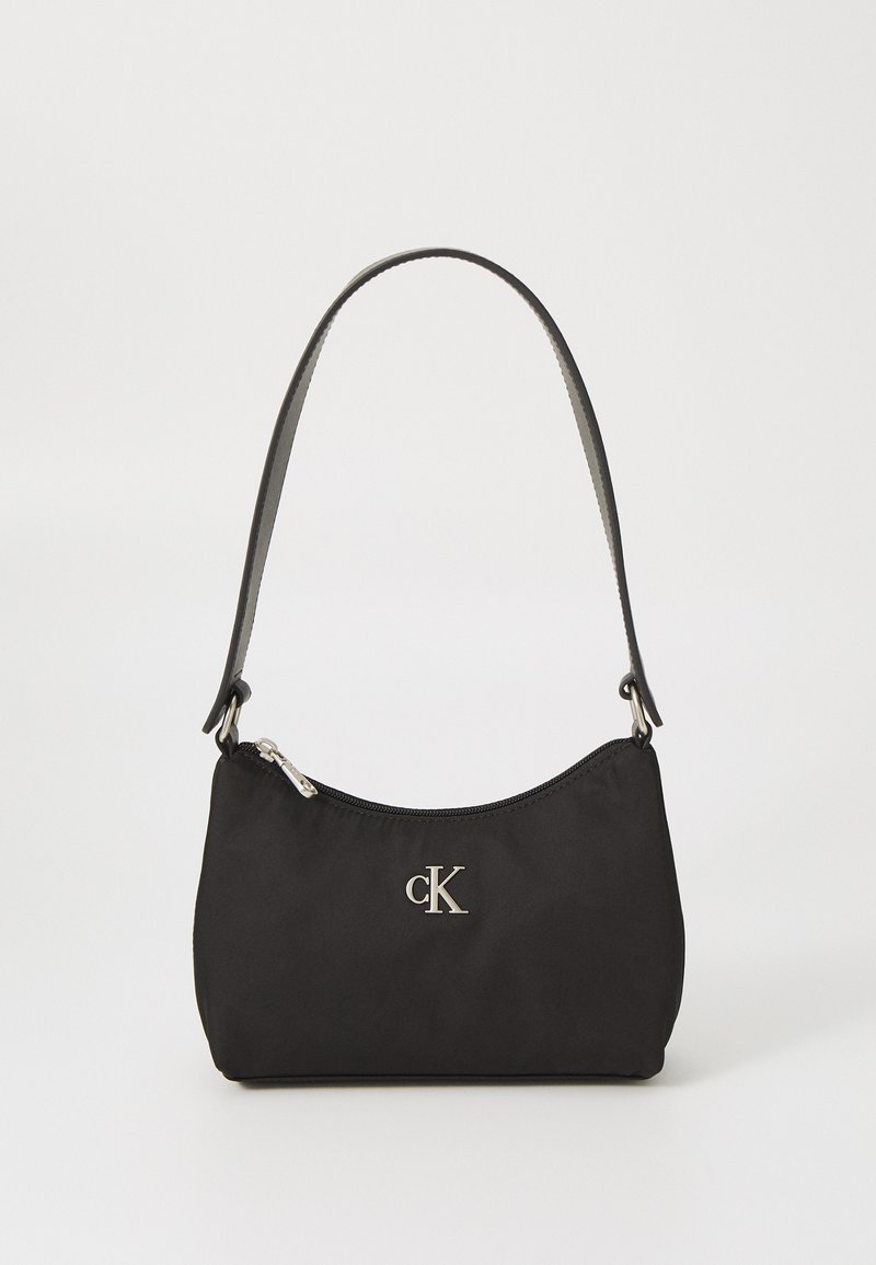 Μαύρη νάιλον τσάντα ώμου με καμπυλωτό σχήμα, ασημένιο φερμουάρ και λογότυπο. Περιέχει λεπτό λουρί και λεία υφή.