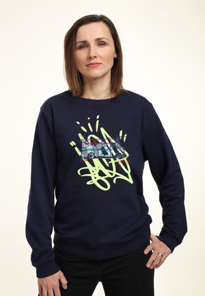 Marineblauwe sweatshirt van zachte stof, met een grote abstracte grafiek in groen en blauw en een graffiti-geïnspireerd ontwerp aan de voorkant.