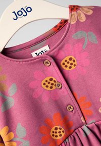 Rosa Baumwollkleid mit floralem Muster und Akzenten in Orange, Gelb und Grün. Knopfverschluss am Hals, geraffte Taille.