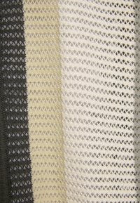 Tejido de malla con franjas alternas de gris oscuro, beige claro, crema y blanco. Patrón de tejido abierto distintivo con una apariencia texturizada.