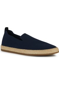 Zapato de lona azul marino sin cordones con un upper de tela texturizada, entresuela envuelta en yute y suela de goma para mayor tracción. Diseño minimalista sin cierres.