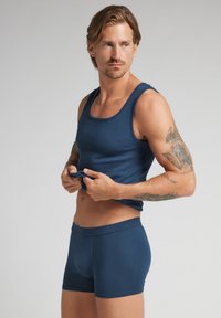 Marinblå ribbad linne och boxershorts i stretchmaterial, med en figurnära design och en mjuk textur.