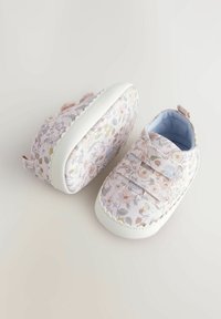 Scarpe con motivo floreale, upper in tessuto rosa e bianco, suola in gomma bianca e chiusure in Velcro. Fodera blu chiaro e una linguetta sul tallone.