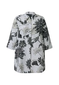 Camisa blanca de manga larga con estampado floral grande en negro y gris, cuello puntiagudo y cierre frontal con botones ocultos.