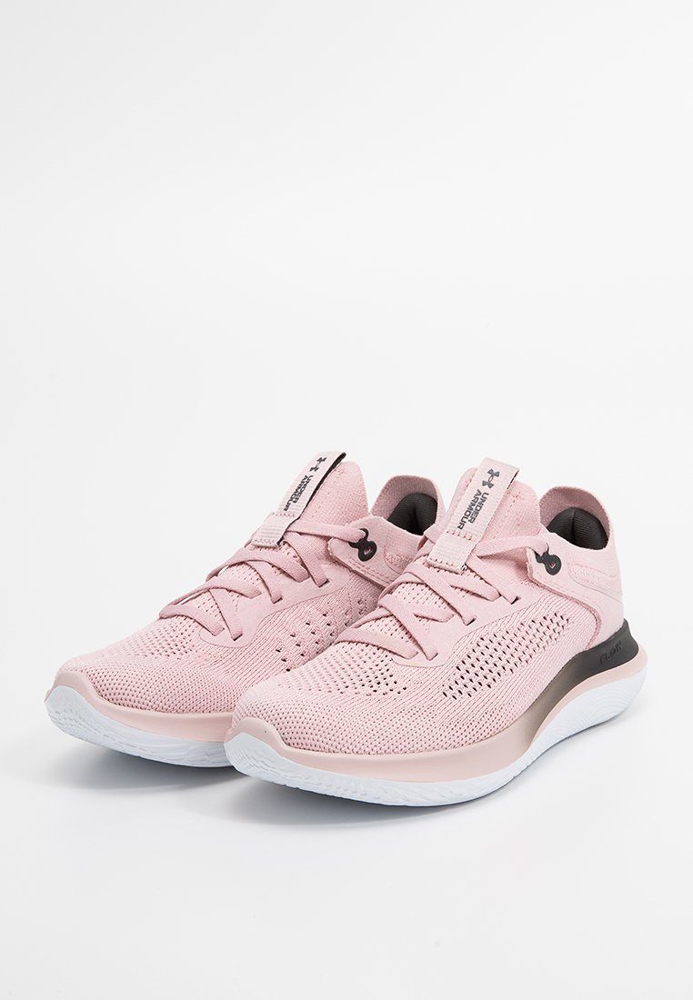 Un par de zapatillas deportivas de punto en rosa claro con suelas blancas y detalles del logo en negro, vista lateral en ángulo sobre un fondo blanco.