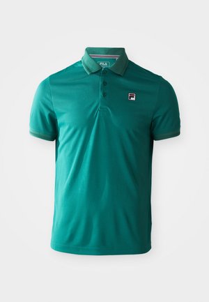 Polo-shirt turquoise à manches courtes avec trois boutons et un petit patch logo FILA sur la poitrine gauche sur fond blanc.
