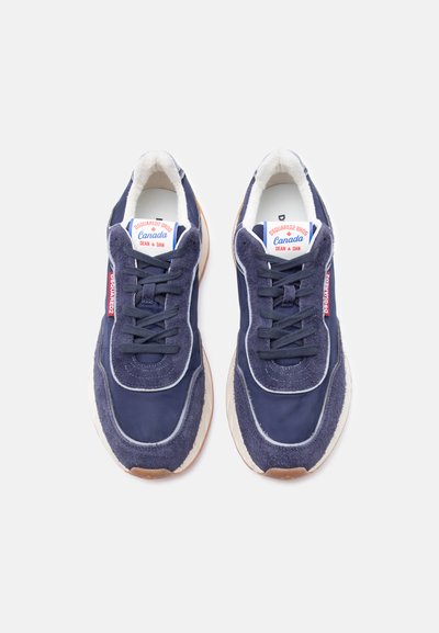 Paire de baskets DSQUARED2 bleu marine avec semelles blanches, lacets noirs et logo rouge sur les côtés et les étiquettes de la languette.