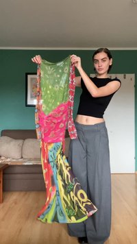 Värviline kangast kleit, mis sisaldab rohelise, roosa ja punase segu, geomeetriliste ja abstraktsete mustritega, näidates voolavat disaini.