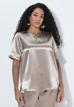 Blusa in satin di un beige chiaro con maniche corte e scollatura a V. Caratterizzata da una texture morbida e una leggera lucentezza; fessure laterali all'orlo.