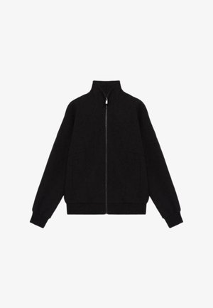 Chaqueta negra de cremallera con un cuello alto, mangas largas, dos bolsillos frontales y un corte relajado con puños y dobladillo de canalé.