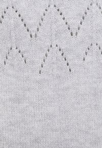 Jasnoszara dzianina zygzakowa z małymi dziurkami. Miękka faktura z delikatnym połyskiem. Subtelna wariacja odcienia w całej tkaninie.