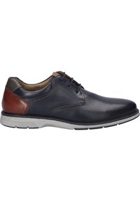 Chaussure en cuir marine à lacets avec design perforé, accent en cuir marron au talon et semelle en caoutchouc grise. Présente une texture lisse et des couleurs contrastées.