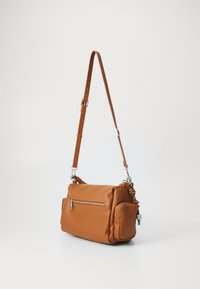 Borsa a spalla in pelle marrone con tracolla removibile, dotata di una tasca con zip frontale, forma arrotondata e accenti laterali testurizzati.