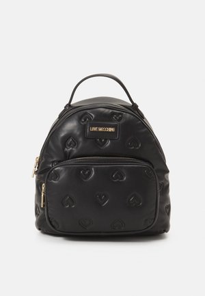 Sac à dos en simili cuir noir avec un motif de cœur embossé, poche zippée à l'avant et quincaillerie dorée. Forme arrondie, poignée supérieure, bretelles ajustables.